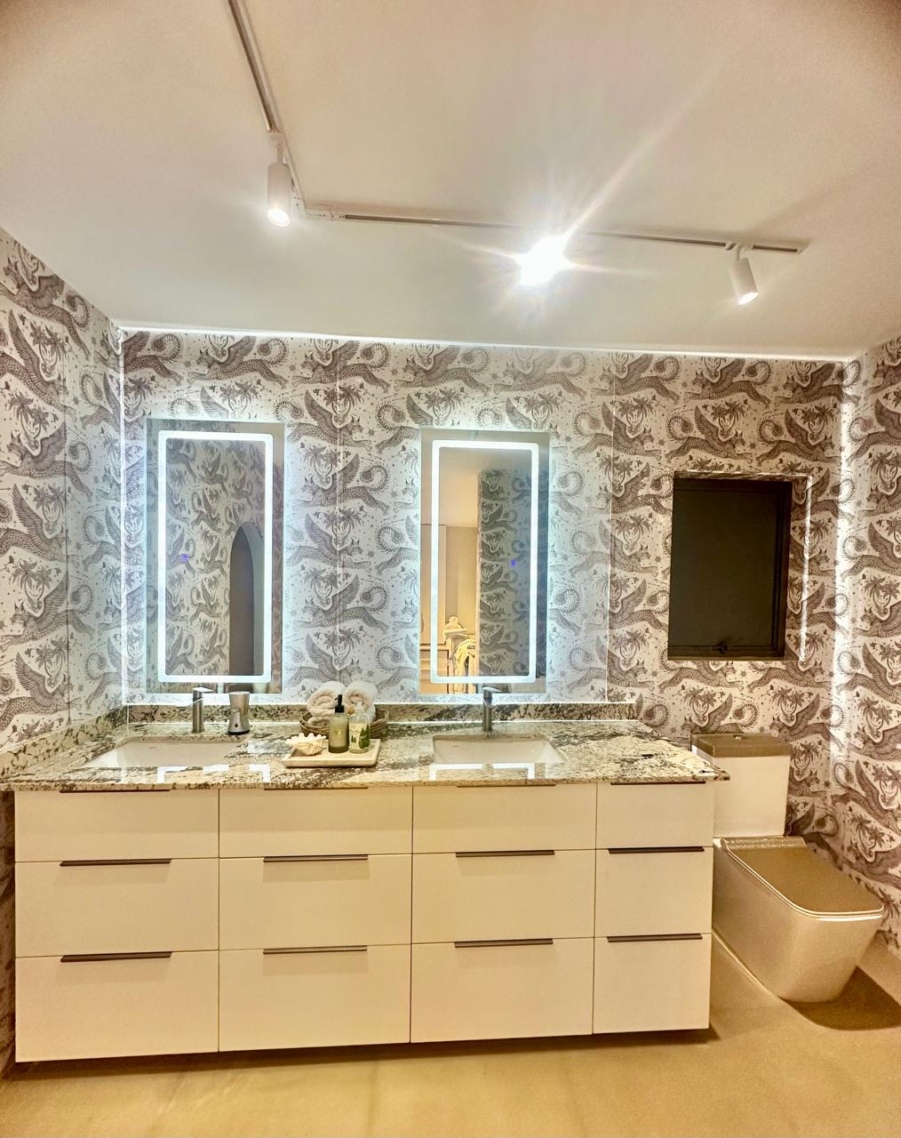 Bespoke bathroom with patterned walls and illuminated mirrors