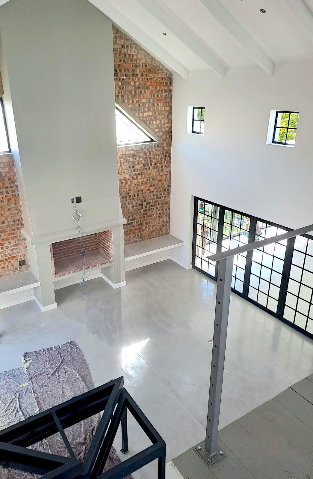 Double-height living space with exposed brick and custom steelwork