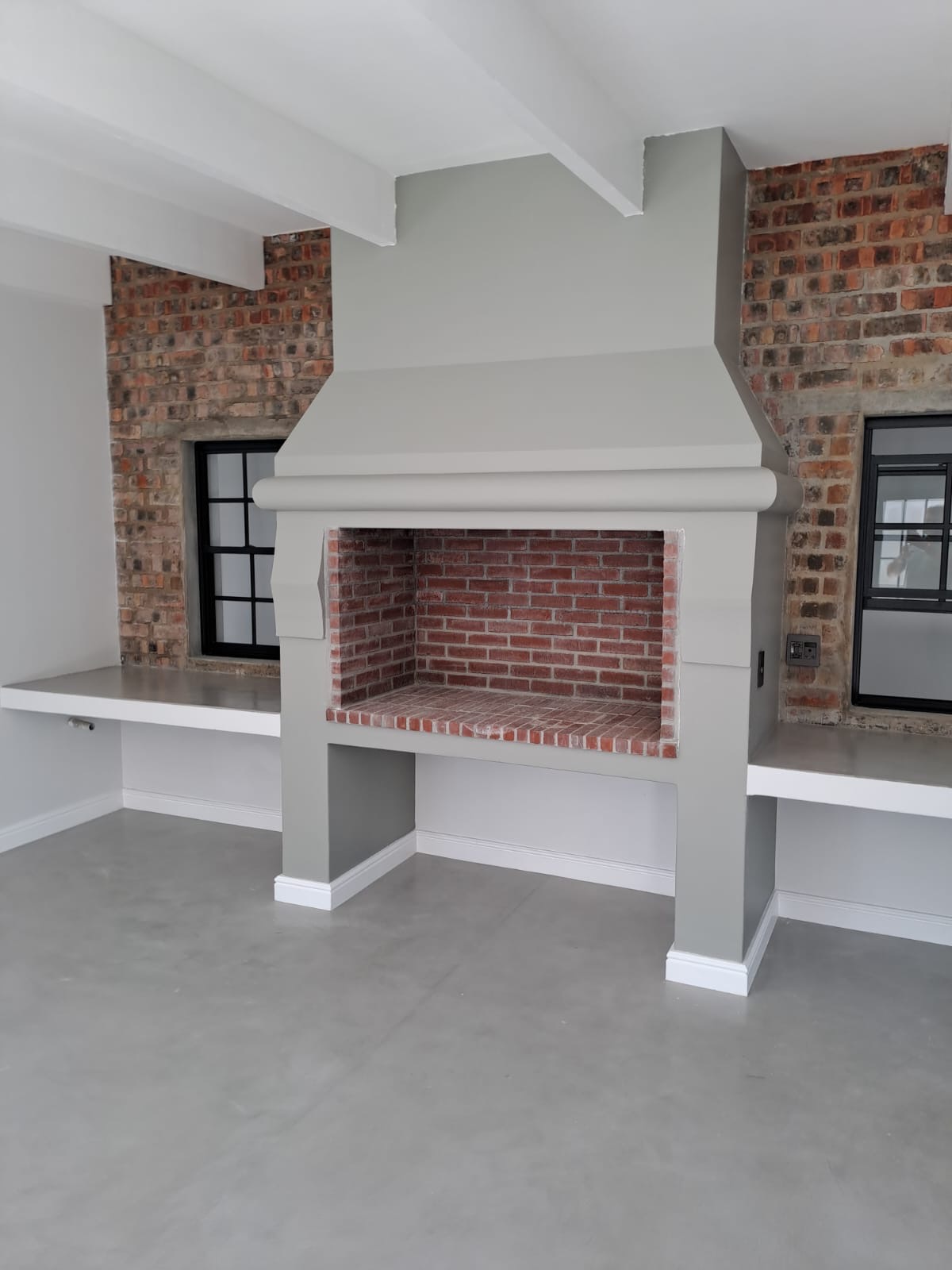 Custom built-in fireplace framed by exposed brick