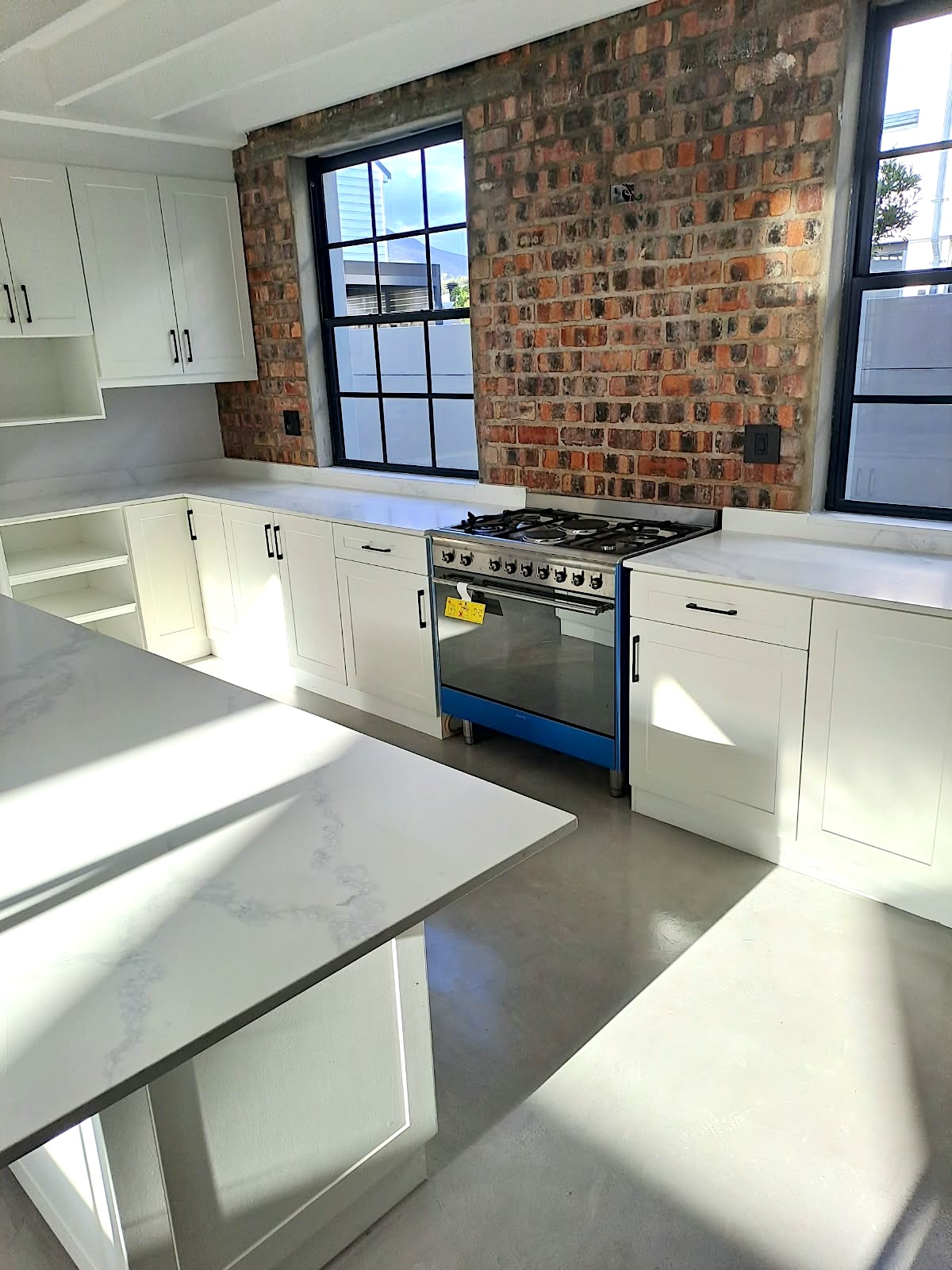 Bright white kitchen with exposed brick and custom cabinetry