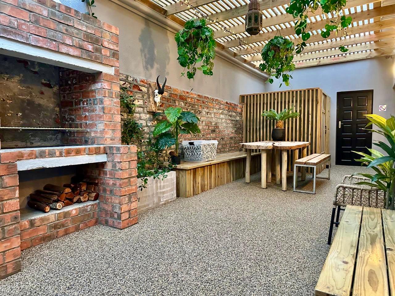 Covered outdoor room with a custom brick braai and timber pergola